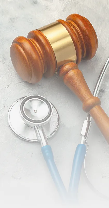 Wooden judge's gavel and blue stethoscope placed on a light gray textured surface.