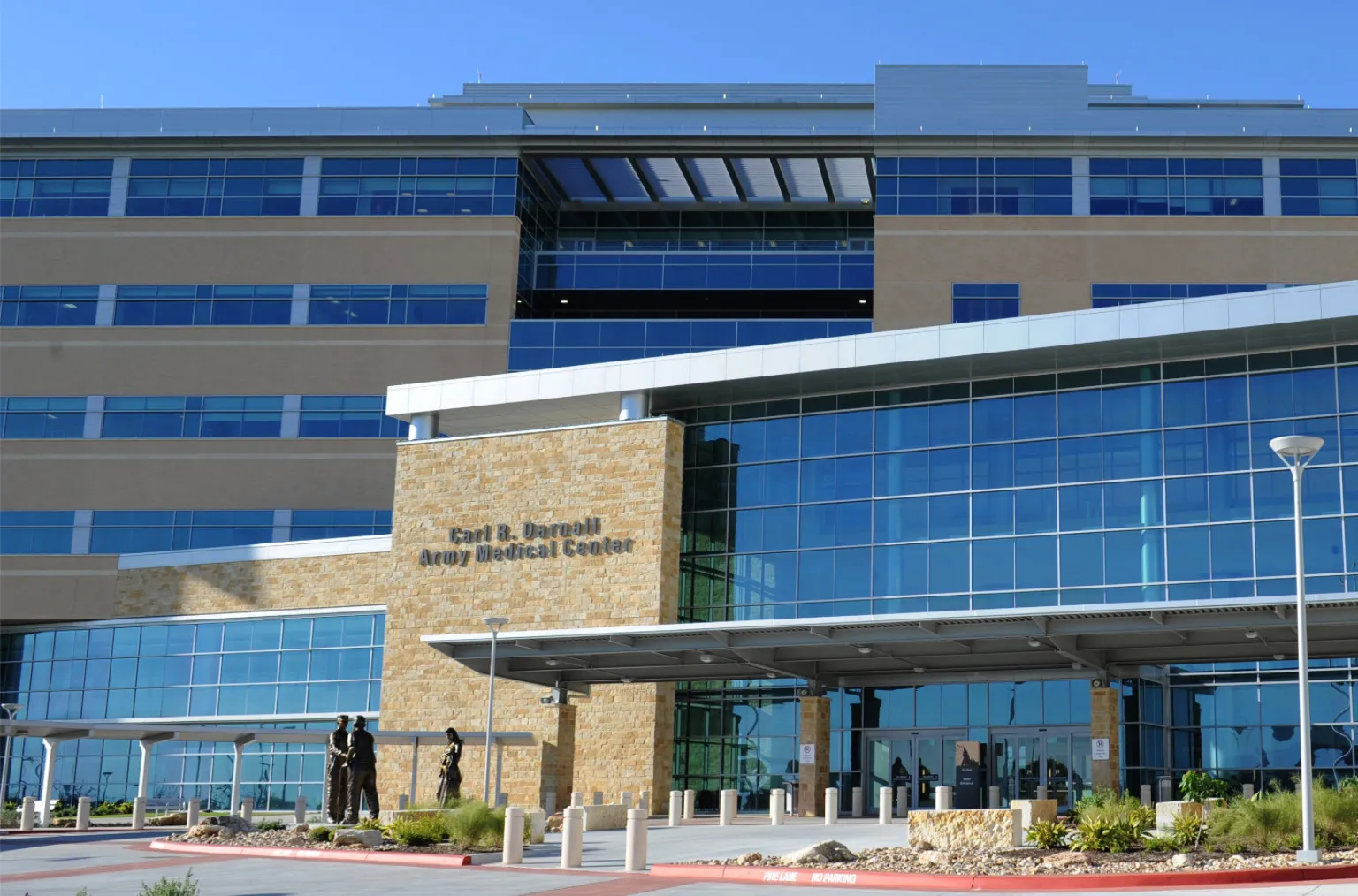 Exterior view of Carl R. Darnall Army Medical Center with modern glass and stone facade.