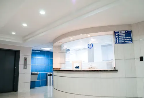 Reception desk area in a modern medical facility with white and blue walls.
