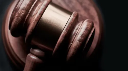 Close-up of a wooden judge's gavel on a dark background.