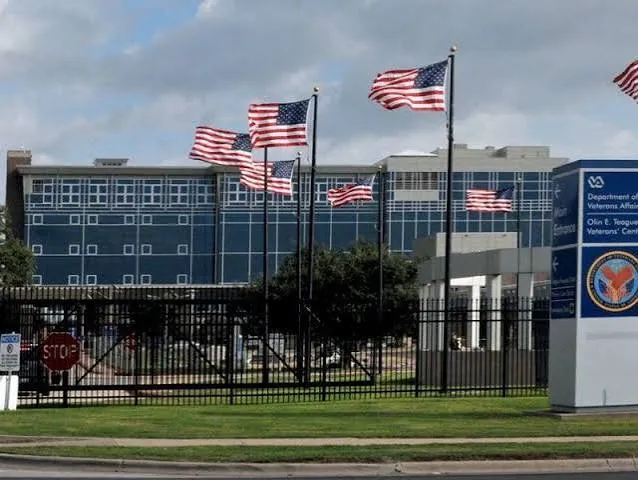 Exterior view of a Department of Veterans Affairs medical center with multiple American flags flying.